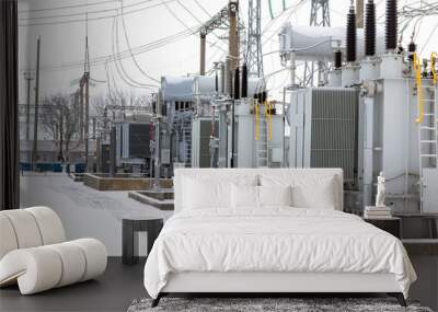 View of the electrical substation. An electrical substation with transformers distributing high voltage throughout the city. High voltage electrical substation in winter. Wall mural