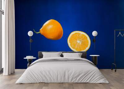 two halves of orange on blue background Wall mural