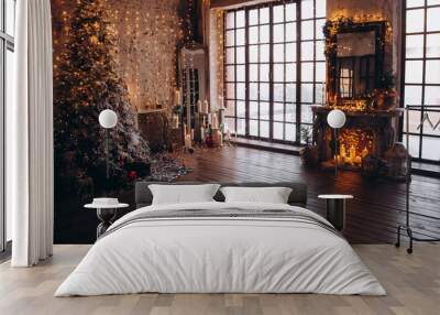 warm cozy evening luxury Christmas room interior design, Xmas tree decorated by gold lights presents gifts, candles,mirror garland lighting fireplace.holiday living room. New year holidays concept Wall mural