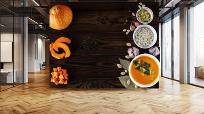 Vegetarian pumpkin cream soup in a white bowl decorated with seeds and herbs on a light background Wall mural