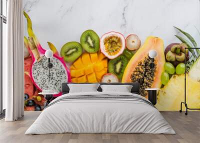 Fresh exotic fruits and tropical palm leaves on white marble background - papaya, mango, pineapple, passion fruit, dragon fruit, melon. Healthy food and diet concept Wall mural