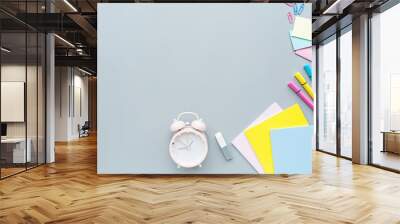 School supplies stationery, colour pencils, alarm clock on gray background, back to school concept with copy space for text, overhead, modern elementary education. flat lay, top view, mockup Wall mural