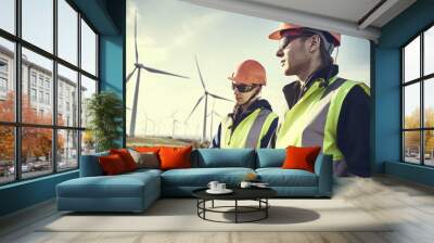 Two workers holding equipment near a wind turbine. Generative AI Wall mural