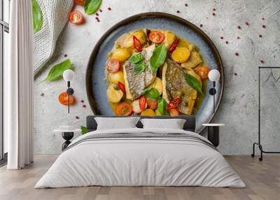 dorado on grill with mini potatoes and artichokes on plate on grey table top view Wall mural