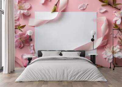 Blank stationery surrounded by cherry blossoms and ribbons on a soft pink background Wall mural