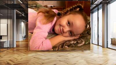 A little girl sitting on a bedundefined Wall mural