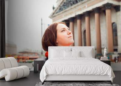 young caucasian woman looking up dreamily outside, portrait of city dweller Wall mural