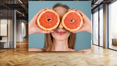 Close-up portrait of topless woman with perfect skin and natural make-up, full nude lips, holding fresh citrus vitamin C grapefruit Wall mural