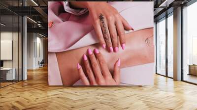 Stylish european woman in elegant beige blazer and golden jewelry, pink bright gel polish nails, posing on pink background Wall mural