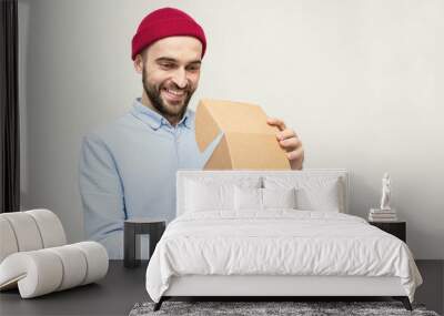 Satisfied bearded opens the box, delivery guy, portrait, white background, copy space, white background, 16:9 Wall mural