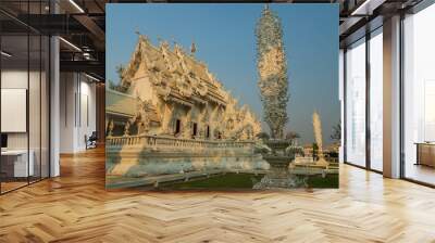 Chiang Rai, Thailand - March 2020: White temple or Wat Rong Khun during sunset. Temple with a sculpture nearby Wall mural