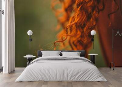 A girl with red curly hair. Nice long hair Wall mural