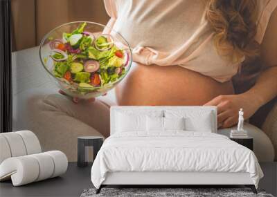 Pregnancy and healthy organic nutrition. Pregnant woman enjoying fresh vegetable salad in bed, free space. Concept of expectation and health. Wall mural