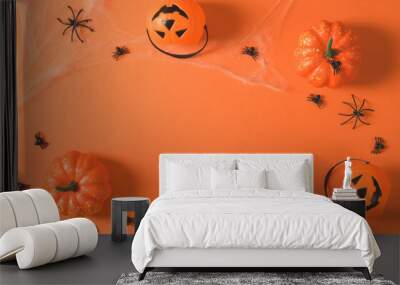 Pumpkins and spiders in a web on an orange background, top view, flat lay. Decorations for Halloween on an orange background, copy space. Halloween party. Wall mural