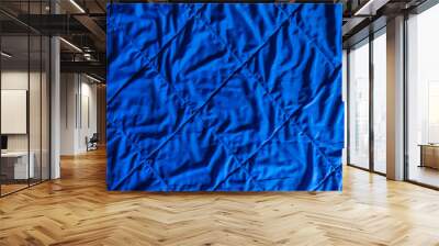 Close-up of the surface of an old quilt. Shiny blue fabric is sewn with square ornamental threads. The surface is slightly wrinkled. Background. Texture. Wall mural