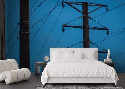 Poles and wires of the power line against the blue evening sky. There is a moon. Background. Wall mural