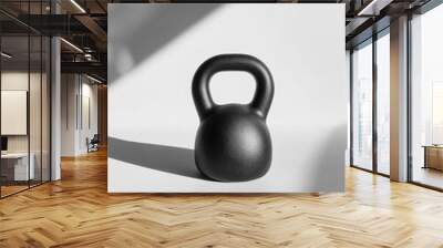 A black kettlebell rests on a clean white surface, illuminated by soft natural daylight, creating a minimal and elegant aesthetic. Generative AI Wall mural