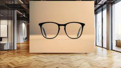 A pair of sleek black eyeglasses rests on a flat surface, illuminated by soft light creating a subtle and elegant atmosphere. Generative AI Wall mural