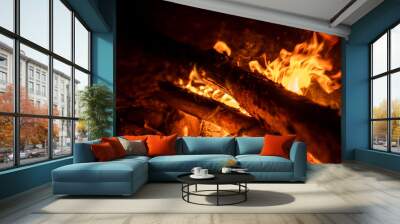 Logs burn brightly in a campfire, casting an inviting glow and warmth during a serene evening in the forest Wall mural