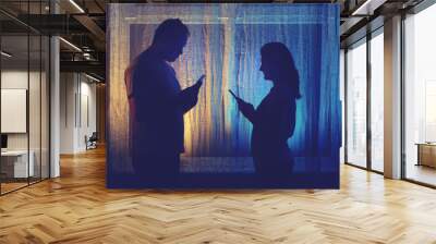 Silhouette of a man and a woman with phones at the night window. Couple husband and wife having relationship problems in the evening light of the home living room Wall mural