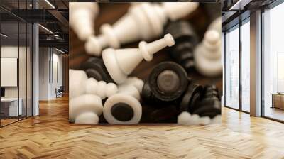 Black and white chess pieces scattered on a wooden table, close-up, selective focus. Wall mural