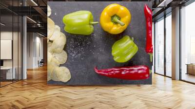 potato chips with hot peppers and paprika on a background of black stone, flat lay Wall mural