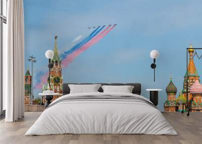 group of military aircrafts flies in formation with three colored smoke in shape of russian flag in  Wall mural