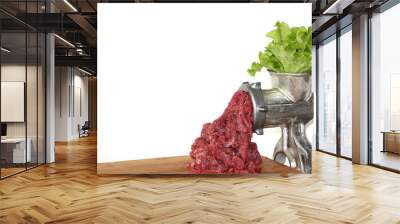 Plant-based meat concept. Green leaves of lettuce salad are inserted into the meat grinder from above, red ground beef comes out of the meat grinder on a wooden cutting board. Copy space for your text Wall mural