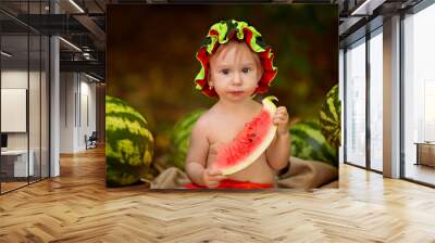 Baby girl sitting outdoors in summer and eating ripe watermelons. Harvesting Wall mural