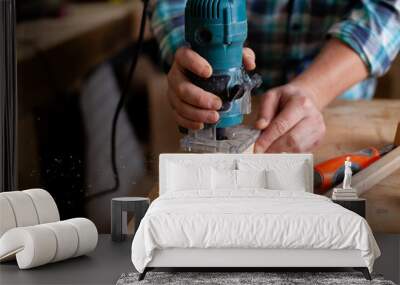  A carpenter in a plaid shirt works a workshop. Wood. Ecological compatibility. Lifestyle. Close up Wall mural