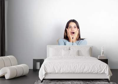 Portrait of a surprised teenage girl. Back to school. The student opened her mouth on a white background. A place for text. Emotions. Shock. Cry. Wall mural