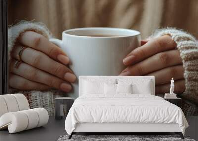 Cozy hands with rings holding a warm coffee mug in soft knit sweater background Wall mural