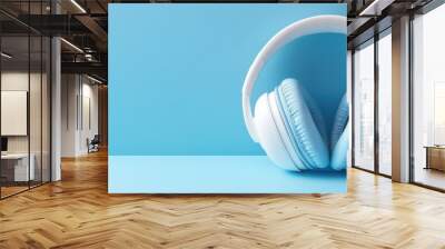 Minimalist blue background with stylish white headphones for modern music lovers Wall mural