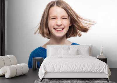 Cute teen girl in a blue sweater is laughing. Isolated over white background. Wall mural