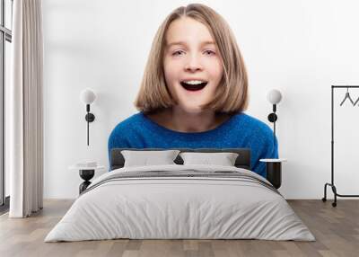 Cute teen girl in a blue sweater laughs. Close-up. Isolated on a white background. Wall mural