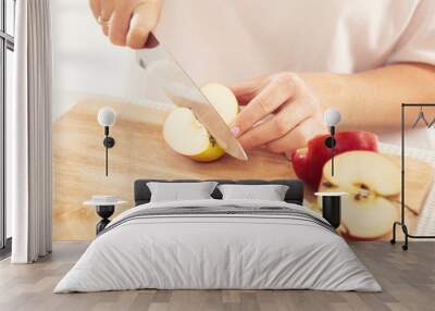 Woman cuts an apple into slices with a knife, close-up Wall mural