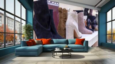 Women's boots with heels on the shelves in the store. Fashion, style and beauty. Close-up. Wall mural