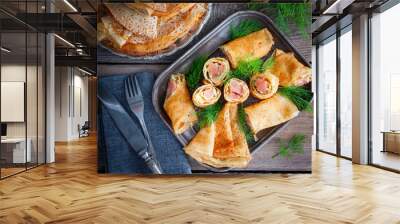 Pancakes stuffed with red fish on a wooden table, top view Wall mural