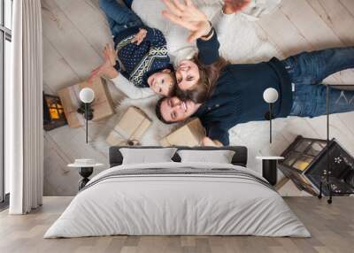 family, mom, dad, son and are looking up, laughing, and pleased on christmas eve/family portrait Wall mural