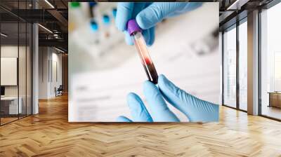 Tubes of blood and blood serum in the hands of the scientist or laboratory for analysis and research Wall mural