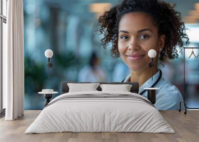 black woman doctor with curly hair, smile and looking at camera with statoscope on blurry hospital background. banner Wall mural