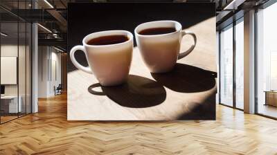 two cups of coffee on wooden background. Beautiful white cups, stylish toning, place for text. Cup of black tea on wooden background. cheerful morning concept Wall mural