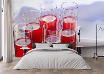 Glass glasses with a drink of red color. Colorful cocktail. Glasses of wine on a white table. Soft and alcoholic drinks Wall mural