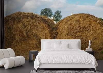 photo of two haystacks over a cloudy sky Wall mural