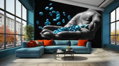 A black and white photo of a female hand covered in blue pills Wall mural