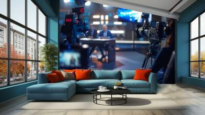 A mock-up television studio features two professional presenters discussing topics such as news, politics, science, celebrity, entertainment, and a cable channel host interviewing guests. Wall mural