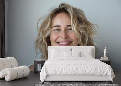 A young blonde smiling and laughing woman isolated on a white background with a clean fresh face 35 years old Wall mural