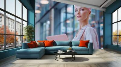 An authentic specialist with short pink hair stands at a table with her laptop computer, focused on her work. She is working on design, data analysis, and plan strategy. Wall mural