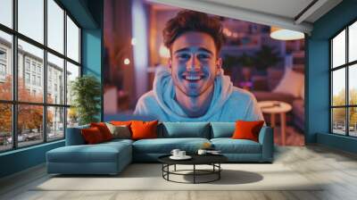 As he uses a personal computer, he nods in agreement and smiles at the camera. A cozy living room is seen in the background. Wall mural