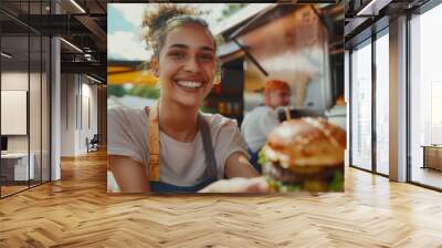 Female Street Food Truck Employee Serves Freshly Made Burgers to a Happy Young Lady. Young Lady Paying for Your Food Using Contactless Credit Card. Street Food Truck in Modern Hip Neighborhood Wall mural